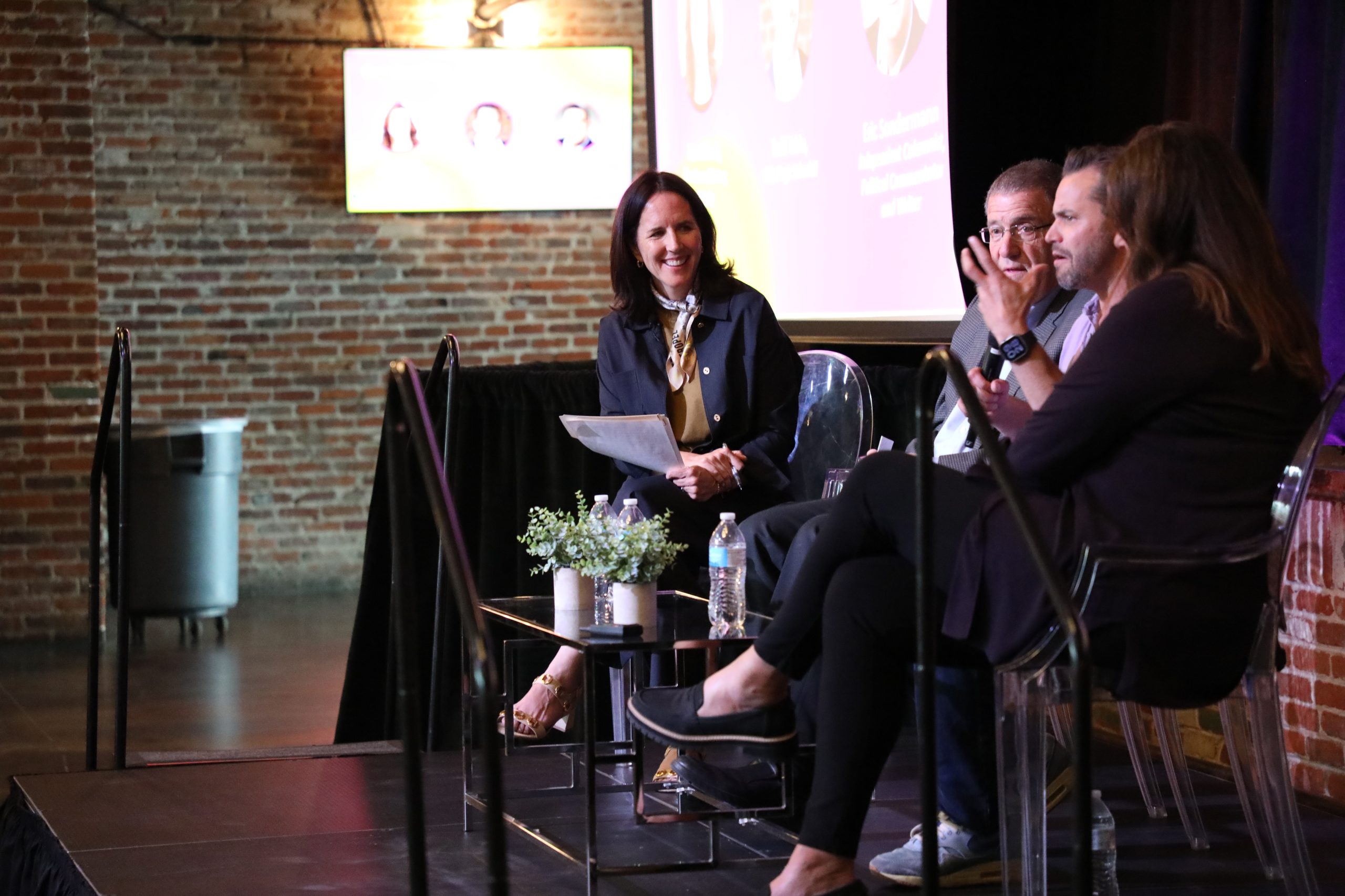 Three professionals on stage seated during a panel at Elevate, an Emergenetics Associate event.
